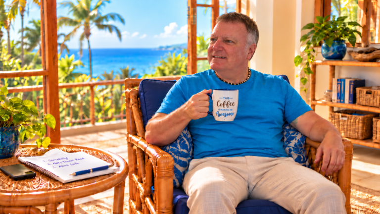 Shane sitting relaxed in a bamboo chair drinking coffee